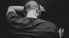Rear View Of Man Using Mobile Phone