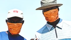 Men wearing and holding up face masks in South Africa's Nkowankowa Township during lockdown - 27 April 2020