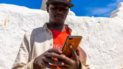 ሞባይል የሚጠቀም ወጣት