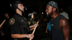 Un manifestante confronta a un policía en Kenosha