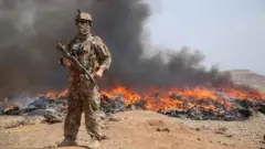 Uwari umusirikare w'ingabo za Afghanistan ahagaze imbere y'inkongi y'umuriro