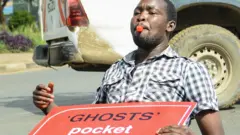 Man sitting on the floor with a placard