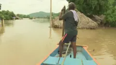 వరద నీటిలో పడవపై వ్యక్తి