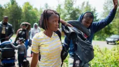 Impunzi zashyize amaboko hejuru, mu gihe zambuka mu buryo bunyuranyije n'amategeko umupaka uhuza Amerika na Canada