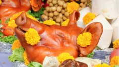 Голова свиньи, украшенная желтыми хризантемами