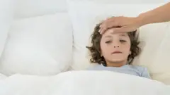 A young chid with fever in bed
