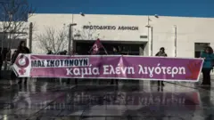 Eleni Topaloudi cinayetini protesto eden kadınlar mahkeme binası önünde ellerinde "Bizi öldürüyorlar" yazılı pankart taşıdı.