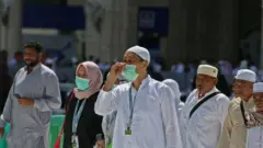 معتمرون يرتدون أقنعة طبية