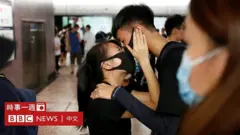香港九龍港鐵美孚站內一對參與「反送中」示威的情侶隔著口罩擁吻（11/8/2019）