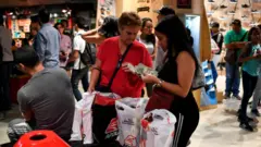 Em shopping, duas mulheres mexem com notas1xbet valorantdólares