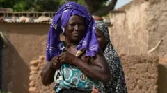 Une femme déplacée interne portant son enfant au dos au Burkina (Photo d'archives)
