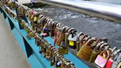 Thousands of padlocks dey attached to di bridge wey dey near River Wye