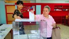 A woman casts her vote during the general elections, at a polling station in Nafplio, Greece, 25 June 2023.