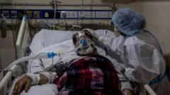 A medical worker tends to a patient suffering from the coronavirus disease (COVID-19), inside the ICU ward at Holy Family Hospital in New Delhi, India, April 29, 2021