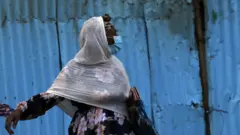የአፍ መሸፈኛ ያደረጉ ሴት