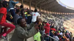 Ndị mmadụ na-agụ egwu iji kwanyere Robert Mugabe ugwu n'akwamozu ya.