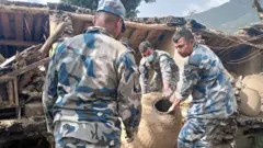भूकम्पले क्षति पुगेको घरबाट सामान निकाल्दै सशस्त्र प्रहरी