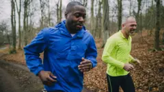 Dois amigos correndo lado a lado na floresta