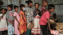 أطفال يتلقون مساعدات غذائية في إقليم تيغراي