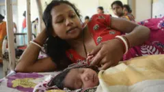 नवजात बच्ची का हाथ पकड़े मां