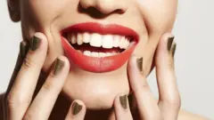 O sorriso de uma mulher em primeiro plano.