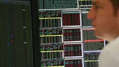 An employee views trading screens
