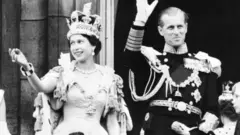 Queen Elizabeth II accompanied by Prince Philip waves to the crowd, 02 June 1953