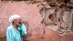Une femme devant sa maison endommagée par le tremblement de terre à Marrakech le 9 septembre.