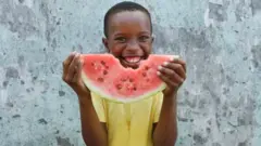 Enfant qui mange une pastèque