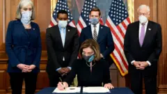 Нэнси Пелоси подписывает документы