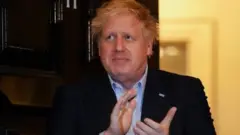 Ông Johnson tham gia vỗ tay hoan hô các nhân viên y tế NHS hôm thứ Năm bên ngoài số 11, phố Downing Street