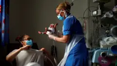 አንዲት ነርስ አዲስ ለወለደች እናት ልጇን ስትሰጥ