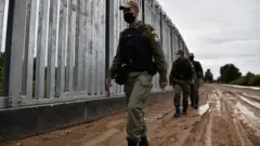 Meriç Nehri kıyısındaki çelik çitin önünde yürüyen YUnan askerleri