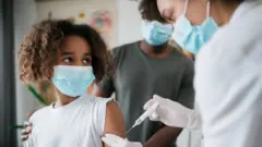 Menina sendo vacinada