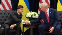Ukraine's President Volodymyr Zelensky and US President Donald Trump shake hands during a meeting in September