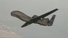 A handout photo made available by the US Navy provided by Northrop Grumman, a RQ-4 Global Hawk unmanned aerial vehicle conducts tests over Naval Air Station Patuxent River, Maryland, USA 25 June 2010