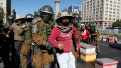 Aba bavumbi bateguye imyiyerekano hanze y'ikirimba c'umukuru w'igihugu ku mugwa mukuru, Santiago.