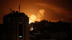 Smoke rises above buildings in Gaza City as Israel launches air strikes late on 6 April 2023