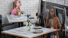 Cardboard cut outs of people are placed at dining tables in a restaurant