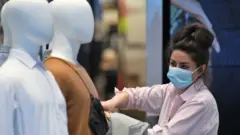 Travailleur de magasin portant un masque facial