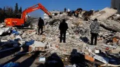 People look on as the search for survivors continues in the aftermath of an earthquake in Kahramanmaras, Turkey, February 8, 2023.