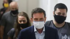 O prefeito do Rio de Janeiro, Marcelo Crivella, é escoltado por policiais após ser detido, em 22 de dezembro de 2020