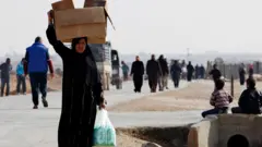 امرأة تحمل متاعها في صندوق على رأسها