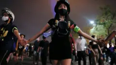 A group of protesters hold hands as they march through Bangkok