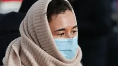 One woman wey wear protective mask forYekaterinburg, railway station