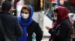 Tahran'da maske takmış İranlılar