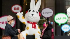 Pedestrians walk past a seasonal promotional display for a department store in Taipei on January 18, 2023, ahead of the Lunar New Year of the Rabbit on January 22.