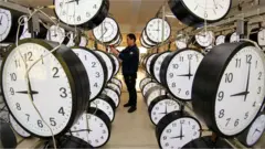 Un hombre junto a filas de relojes