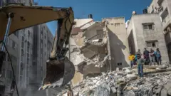 Palestinians inspect a destroyed house, after it was struck by Israeli strikes, in Gaza City, May 16, 2021