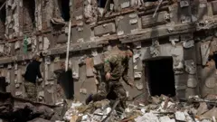 ハルキウの破壊された市街を歩くウクライナ兵